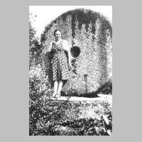 074-0021 Tochter Christel Lemcke im elterlichen Garten vor einem Muehlstein.jpg